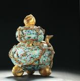 Estimated at $15,000-25,000, this vibrant cloisonne censer is especially sought after due to the double peach form.  With twelve gilt bats and seven small gilt peaches, the 8.5” high piece is marked “Qian long Nian Zhi”.