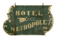 Lot 468 to sell at Garth's March 15 auction.  HOTEL SIGN.  Massachusetts, mid-19th century, wood.  Double-sided sign with "Hotel Metropole" and a pointing hand.  Wear.  36"h.  55.5"w., not including hanging brackets.  This sign originally hung near the Hotel Metropole in Brookfield, Massachusetts.  Included with the lot art two copies of photographs: one of the Metropole, and the other a town view with a horse-drawn pumper and this sign hanging on the lightpost pointing toward the Metropole.  Es