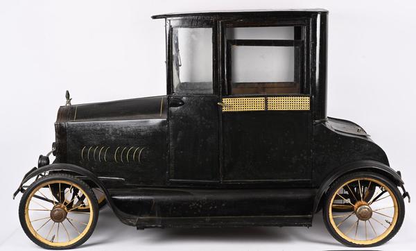 American National Deluxe Coupe pedal car, luxury version with opening doors, sliding windows, interior upholstery and curtains.  Length: 68 inches.  Sold for $66,000 against an estimate of $20,000-$40,000