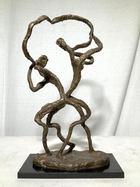 This abstract figural bronze sculpture ($400-600), signed Estelle Goodman, of a man and a woman, with their backs to one another yet connected by a figurative representation of communication in the form of a flowing ribbon between their mouths.  It stands 18¼ inches tall.