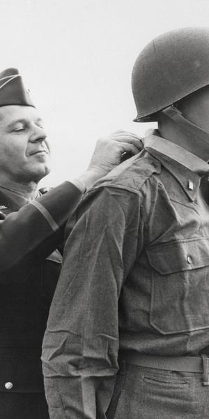 Ernest Childers (Muscogee [Creek]) receives the Congressional Medal of Honor from Lieutenant General Jacob L.  Devers (left).  5th Army headquarters, April 8, 1944.  