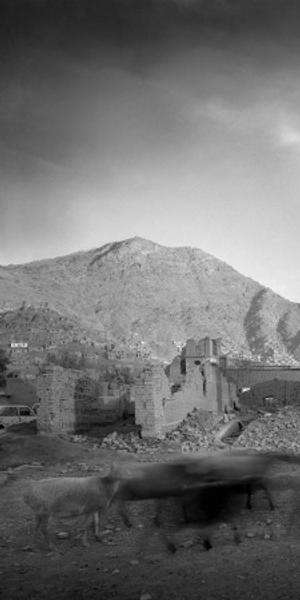 Image: Simon Norfolk, Bullet-Scarred Apartment Building and Shops, Karte Char District, Kabul, Afghanistan, Archival pigment print, From the series Afghanistan: Chronotopia, Loan and image courtesy of the photographer and Gallery Luisotti, Santa Monica, CA