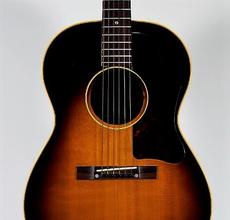 1957 Gibson LG-2 acoustic guitar with a sunburst finish over its spruce top and mahogany back and sides, in very good condition (est.  $2,000-$3,000).