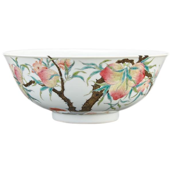 Lot 411 Chinese Famille Rose Enameled Porcelain Bowl, Qing Dynasty/ The delicately rounded sides painted on the exterior with blossoming and flowering peach branches, the leafy stems extending over the rim to the interior where three iron red bats fly amid the pink blossoms, base with four-character hallmark in iron red.  Diameter 6 5/8 inches.  Provenance: Douglas J.  K Wright Ltd., London/ From the Estate of Peter K.  Warren.  Estimate: $15,000-25,000 