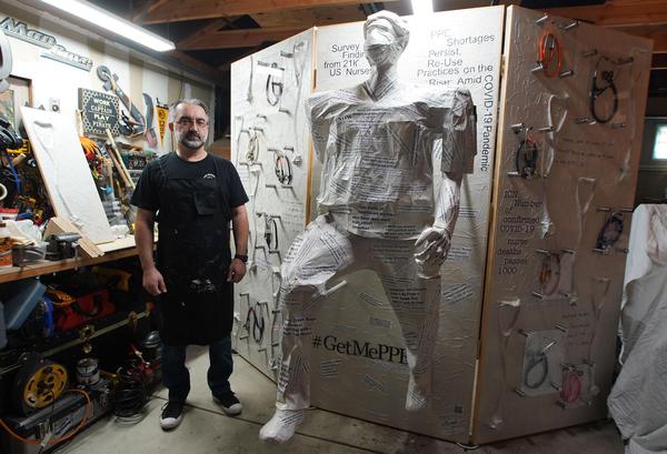 Cal State LA Nursing Professor and Woodland Hills resident Ali Tayyeb with his artwork honoring health care workers.  (Credit: J.  Emilio Flores/Cal State LA) 