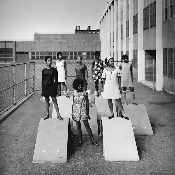 Photo shoot at a public school for one of the AJASS-associated modeling groups that emulated the Grandassa Models and began to embrace natural hairstyles, by Kwame Brathwaite, in "Black is Beautiful: The Photography of Kwame Brathwaite," at MoAD.