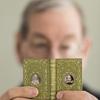 Neale Albert holding 3" book “Julius Caesar” bound by Santiago Brugalla, 2004, one of the volumes of the Knickerbocker set of Shakespeare.  Bound in green goatskin, with gold and red tooling.  Miniature portrait medallions, painted by John Hodgson, on front and back covers in imitation of a Cosway-style binding.  