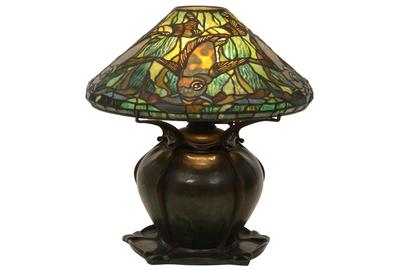 A rare Tiffany Studios leaded glass aquatic fish lamp ($80/100,000) on a bronze pumpkin base has a shade surrounded by five swimming fish in gold mottled glass, 17½ inches tall with a 16- inch diameter shade.