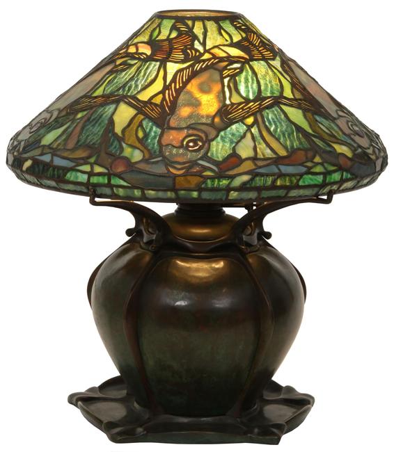 A rare Tiffany Studios leaded glass aquatic fish lamp ($80/100,000) on a bronze pumpkin base has a shade surrounded by five swimming fish in gold mottled glass, 17½ inches tall with a 16- inch diameter shade.