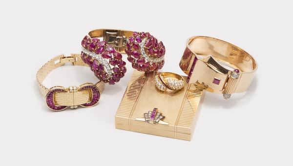 A selection of jewelry from The October Auction including a Van Cleef & Arpels covered wristwatch, a Boucheron carved ruby cuff bracelet, and a Raymond Yard compact.