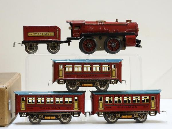 1930s Ives wind-up train set #1590 in original box.  Painted sheet metal 0-4-0 steam locomotive with Ives R.R.  Lines tin-litho tender and three Pullman cars.  Estimate $300-$600