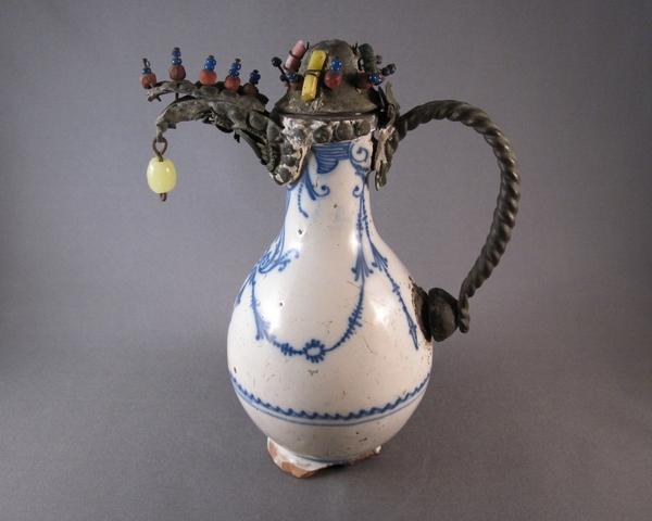 A 17th-century Dutch delft ewer with a replaced jeweled metal spout and handle