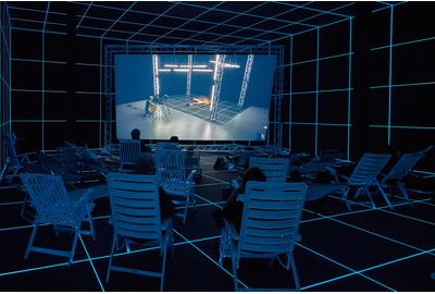 Hito Steyerl, "Factory of the Sun," 2015.  Single channel high definition video, environment, luminescent LED grid, beach chairs, 23 minutes.  Installation view from the Venice Biennale, German Pavilion, 2015.  Image courtesy of the Artist, Andrew Kreps Gallery, New York and Esther Schipper, Berlin.  Photography by Manuel Reinartz.