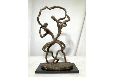 This abstract figural bronze sculpture ($400-600), signed Estelle Goodman, of a man and a woman, with their backs to one another yet connected by a figurative representation of communication in the form of a flowing ribbon between their mouths.  It stands 18¼ inches tall.