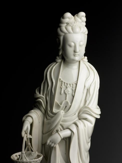 A Dehua Guanyin Holding A Basket With Fish 19th Century Estimate $6,000-8,000 