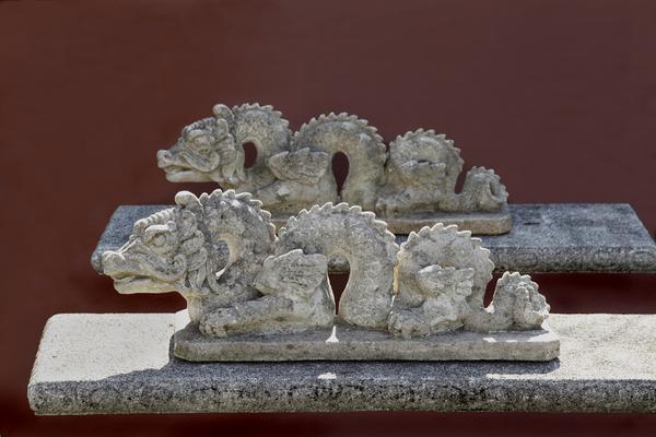 Aileen Minor shows a pair of antique dragon sculptures.