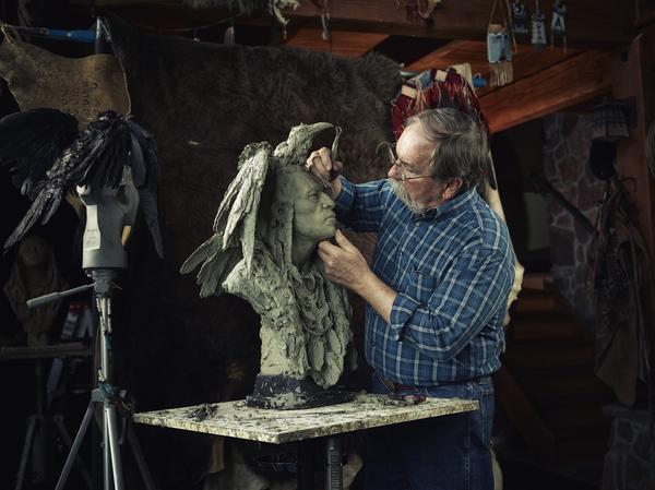 Artist John Coleman sculpting "Two Ravens" 