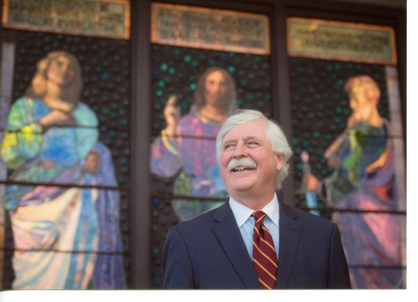 William Vareika in front of John La Farge stained glass windows he and his wife Alison donated to the McMullen Museum, Boston College.