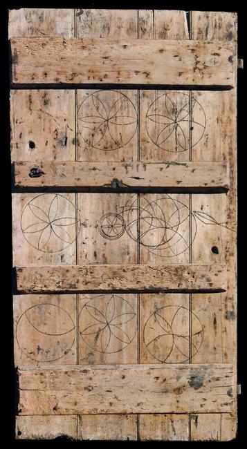 Oak calf-shed door marked with magical symbols to protect livestock.  From Laxfield, Suffolk, 19th century.  183 x 94 cm.  