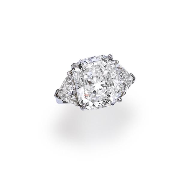 A diamond ring centering a cut-cornered rectangular modified brilliant-cut diamond, weighing 12.13 carats, with triangular-shaped diamond shoulders in a plain mount; Sold for US$ 482,500