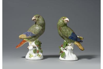 An Important Pair of Early Meissen models of South American Parrots, modelled by Johann Joachim Käendler each perched upon a white tree stump and looking to one side, beautifully naturalistically coloured, each representing a Green Amazon Parrot painted in green with puce detailing to its plumage, and with red, blue and yellow wing tips and tail, the tree stumps issuing leafy berried branches.  Circa 1738-42 1st height: 7 ¾ in (19 ½ cms)2nd height: 7 ½ ins (19 cms) 