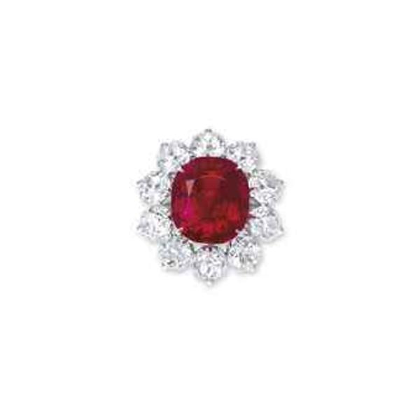 An extraordinary ruby and diamond ring.  Set with a cushion-shaped ruby, weighing approximately 15.04 carats, within a cushion-shaped diamond surround, to the pavé-set circular-cut diamond three quarter-hoop, mounted in gold, ring size 5 1/2.  Sold for HK$141,800,000 ($18,382,385)