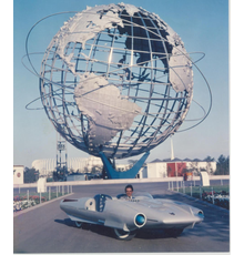 Concept car designer/fabricator John Bucci (Italian/American, 1935-2019) at the 1964 New York World’s Fair, where his 1962 fiberglass car ‘La Shabbla,’ thrilled millions of visitors at the Cavalcade of Cars exhibition.  The car is entered in an online-only auction with bidding through October 14.  Estimate $50,000-$75,000.  Archival photo from the Estate of John Bucci.  