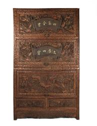 Chinese huanghuali lotus cabinet, elaborately carved all over in three-dimensional designs.  The three top doors lift up and slide in, and there are two drawers underneath (est.  $2,000-$4,000).