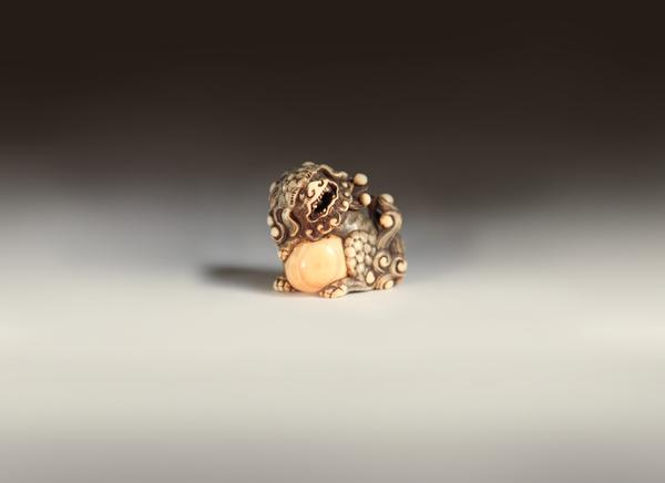 An 18th century Japanese Ivory Netsuke Shishi and Ball, attributed to Harutada 