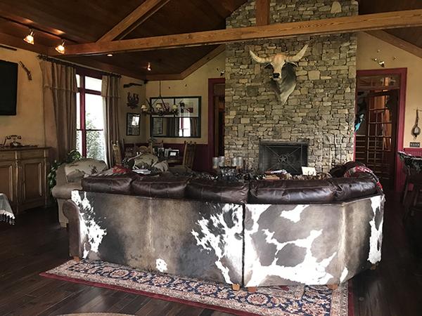 The sprawling, western-themed ranch property includes a home, a separate 'saloon' entertaining area guest house (interior shown), a wine cellar, horse stables, stocked ponds and outbuildings.