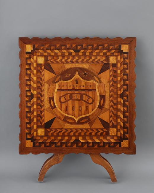 Independent Order of Odd Fellows Marquetry Table.  James J.  Crozier (1867–1950) Probably Islip, New York, 1933.  Wood, 33 3/4 x 33 3/4 x 27 1/4." Collection American Folk Art Museum, New York Gift of Kendra and Allan Daniel, 2015.1.160 