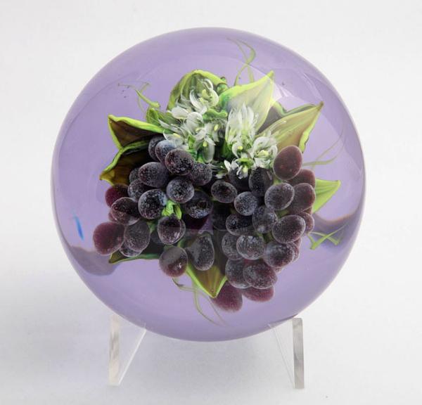 A Rick Ayotte paperweight with a cluster of grapes