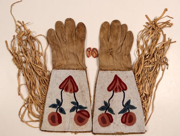 Pair of Native American “Gauntlet Gloves” made from elk skin with elaborate beadwork, circa 1900-1920, by one of the Northern Plains Tribes, plus a pair of tiny fantasy moccasins ($500).