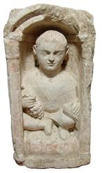 Large Coptic limestone funerary stela, 4th or 5th Century, depicting a youth kneeling upon a soft chair or pillow within a domed niche supported by Corinthian columns (est.  $6,500-$9,000).  