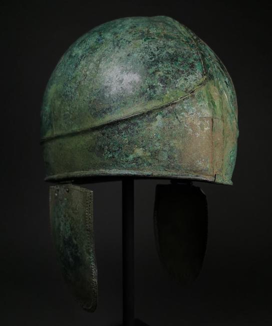 Rare two-part Greek bronze Chalcidian helmet, circa 500-300 BC, Classical to Alexander the Great period.  High-crested crown and hinged cheek pieces.  Perfect condition with beautiful patina.  Estimate £15,000-£30,000