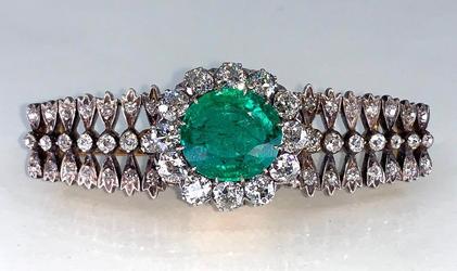 Antique Colombian emerald, gold, diamond and platinum brooch with a bracelet top and a center oval-cut emerald, surrounded by twelve old European cut diamonds (est.  $5,000-$7,000).