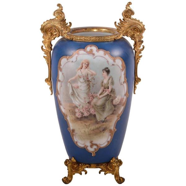 Unmarked, 17.5-inch-tall Wave Crest vase (10 inches across handles), with a hand-painted scenic decor on front and back and gilt metal feet.