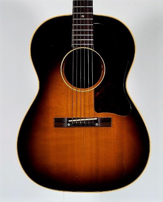 1957 Gibson LG-2 acoustic guitar with a sunburst finish over its spruce top and mahogany back and sides, in very good condition (est.  $2,000-$3,000).