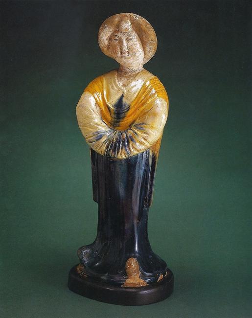 Tang dynasty figure of a standing court lady, featuring a rare deep blue glaze.  This eighth - century ceramic figure was a prized possession of Mr.  Rockefeller’s mother, and was later displayed in Mr.  Rockefeller’s office at 30 Rockefeller Plaza.  