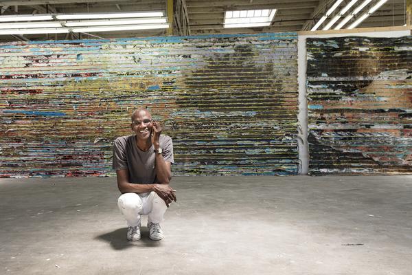 Mark Bradford, seen in his Los Angeles studio with a detail of Pickett's Charge, 2017.  Mixed media.  Courtesy of the artist and Hauser & Wirth.