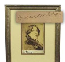 Sepia tone bust portrait photograph of Irish author Oscar Wilde (1854-1900), in an overcoat with a wide fur collar, signed as “Oscar Wilde” and dated “Jany.  23 ‘82” (est.  $6,000-$7,000).