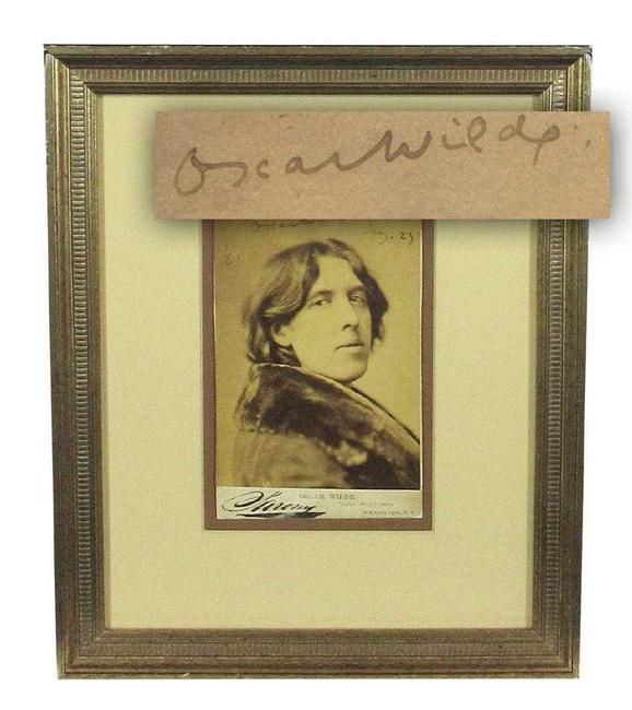 Sepia tone bust portrait photograph of Irish author Oscar Wilde (1854-1900), in an overcoat with a wide fur collar, signed as “Oscar Wilde” and dated “Jany.  23 ‘82” (est.  $6,000-$7,000).