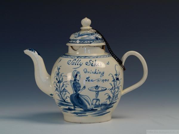 An illustrated Staffordshire creamware teapot with “Sally Sikes Drinking Tea, 1780” inscription