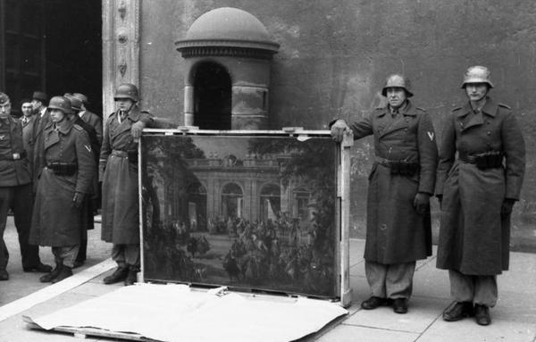 Rome, Italy, 4 January 1944.  German soldiers of the Division "Hermann Göring" posing near the main entrance of Palazzo Venezia showing a picture taken from the National Museum of Naples Picture Gallery (today at the Museo di Capodimonte) before the city liberation, during a propaganda ceremony aimed to prove that the artworks are being "devolved" to the RSI.  