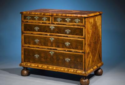 Oysterwood veneers, parquetry and bun feet distinguish this rare and exquisite William and Mary period chest.