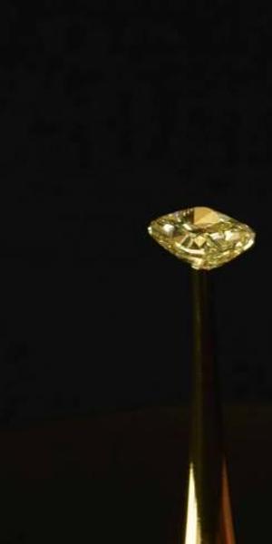 The MIT team cloaked a 16.78-carat natural yellow diamond in their material to show how it disappeared into darkness.