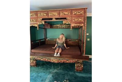 An auction standout is this over-the-top Chinese opium bed ($500-5,000) that is elaborately decorated and carved, measuring 100 inches tall.