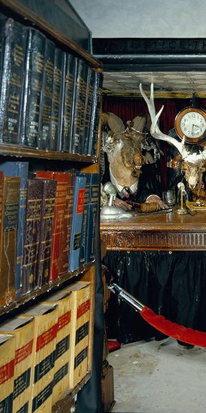 Edward & Nancy Kienholz / The Caddy Court (detail), 1986-1987 / mobile tableau: 1978 Cadillac with 1966 Dodge van, plaster casts, photographs, wood, metal, cloth, books, paint, polyester resin, light, shelves, curtain, antlers, animal skulls, taxidermy animal heads, clothing, furniture, clock, American flag, microphones, pitcher, glasses, gavel / 84 x 276 1/2 x 100 in.  (213.4 x 702.3 x 254 cm).