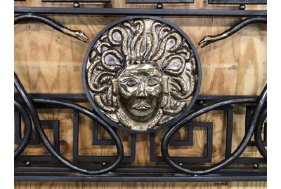 A custom made Versace bed frame replica ($5/10,000) made by an artisan metalworker in Maine is crafted from iron, bronze and brass.  It features an exact detailing of a Medusa head, framing snakes, Greek key design and originally cost $40,000; 70 by 82 inches.  