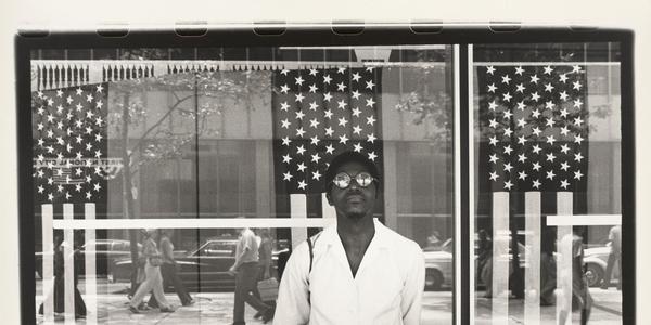 Ming Smith, America seen through Stars and Stripes, New York City, New York, printed ca.  1976.  Gelatin silver print, sheet: 15 3/4 × 20 in.  (40.01 × 50.8 cm), image: 12 1/2 × 18 1/2 in.  (31.75 × 46.99 cm).  Virginia Museum of Fine Arts, Adolph D.  and Wilkins C.  Williams Fund, 2016.241.  © Ming Smith